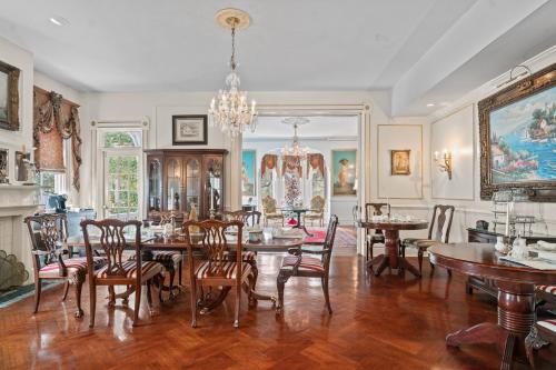 a dining room with tables and chairs and a chandelier at Amethyst Garden in Savannah