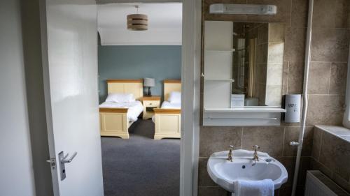 a bathroom with a sink and a bedroom at The Star Inn in Lingfield