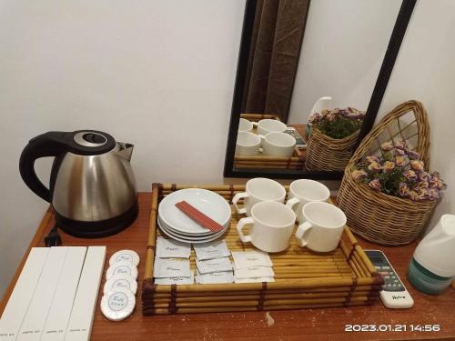 - une table avec des tasses, des assiettes et une bouilloire dans l'établissement ISLANDERS INN - CORON, à Coron