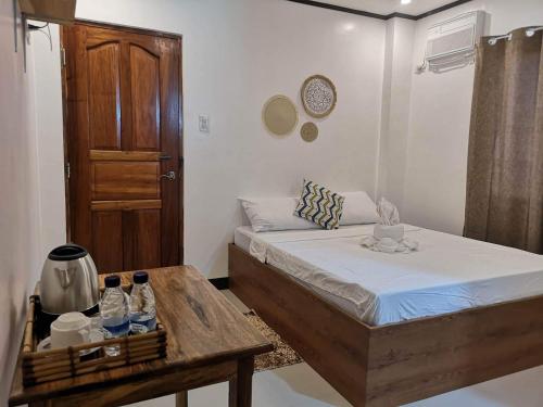 a small bedroom with a bed and a table at ISLANDERS INN - CORON in Coron