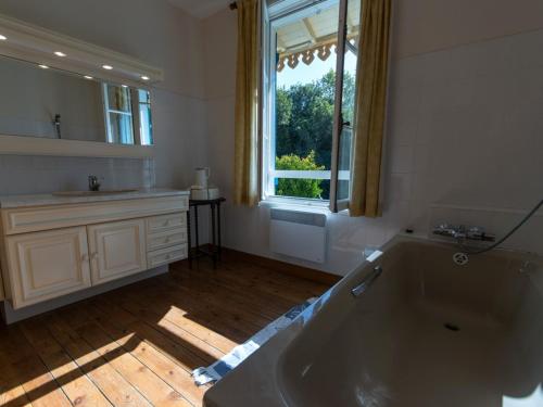 ein Bad mit einer Badewanne, einem Waschbecken und einem Fenster in der Unterkunft Maison Le Palais, 4 pièces, 6 personnes - FR-1-418-20 in Le Palais