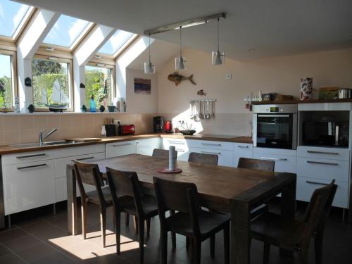Il comprend une cuisine avec une table et des chaises en bois. dans l'établissement Moderne maison avec jardin et terrasse, 4 chambres, proche du bourg de Sauzon - FR-1-418-23, à Sauzon