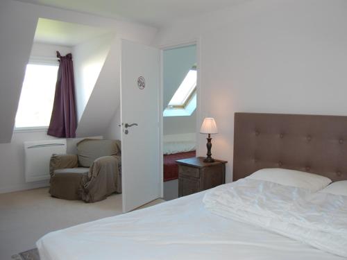 a bedroom with a bed and a chair and windows at Maison Sauzon, 5 pièces, 8 personnes - FR-1-418-23 in Sauzon