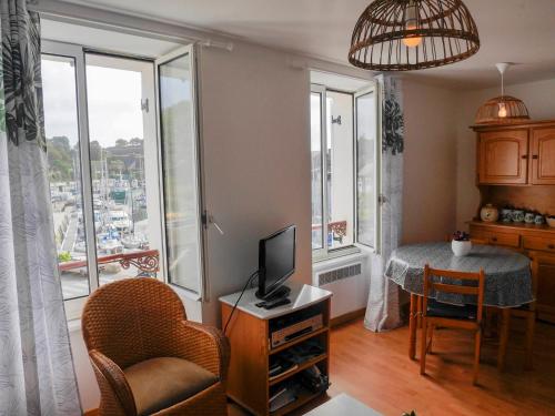 un salon avec une télévision et une table avec une chaise dans l'établissement Appartement 4 pers, cuisine équipée, vue port, proche commodités - FR-1-418-62, au Palais
