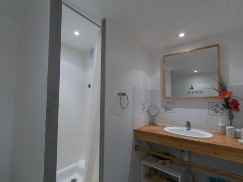a bathroom with a sink and a mirror and a tub at Appartement Le Palais, 4 pièces, 6 personnes - FR-1-418-58 in Le Palais