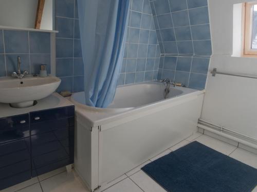 bagno piastrellato blu con vasca e lavandino di Appartement Le Palais, 3 pièces, 4 personnes - FR-1-418-99 a Le Palais