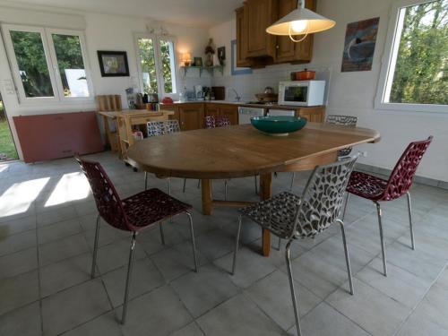 une cuisine et une salle à manger avec une table et des chaises en bois dans l'établissement Maison calme près plage, animaux acceptés, sans wifi ni TV - FR-1-418-119, à Locmaria