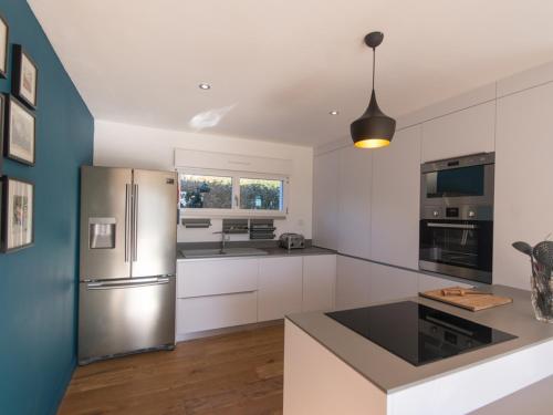 une cuisine avec des armoires blanches et un réfrigérateur en acier inoxydable dans l'établissement Maison contemporaine indépendante, proche plage et centre-ville, 4*, animaux acceptés, avec WIFI - FR-1-418-124, au Palais