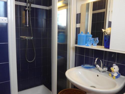 une salle de bain avec un lavabo et une douche dans l'établissement Maison de charme près de la côte sauvage avec jardin et terrasse - FR-1-418-128, à Locmaria