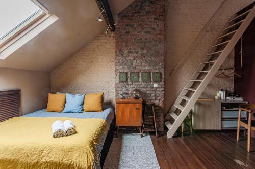2 camas en una habitación con una pared de ladrillo en Comenstay Brussels, en Bruselas