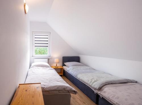 3 camas num quarto no sótão com uma janela em Domki całoroczne U Iwony em Kudowa-Zdrój