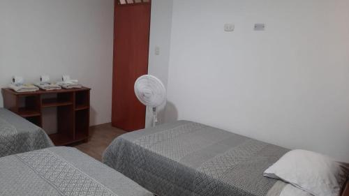 a hotel room with two beds and a fan at Hospedaje Margarita in La Merced