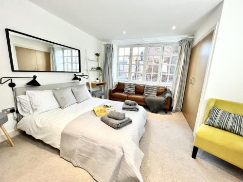 a bedroom with a large white bed and a yellow chair at City Centre Luxury Leicester Apartment in Leicester
