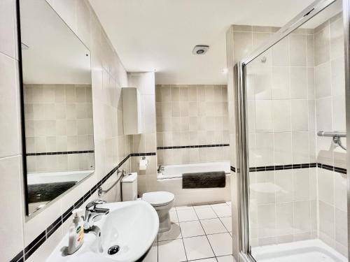 a bathroom with a shower and a sink and a toilet at City Centre Luxury Leicester Apartment in Leicester