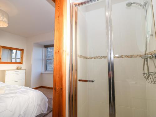 a bathroom with a shower with a glass door at 4 Y Bae in Holyhead