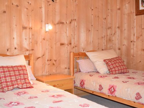 deux lits dans une chambre aux murs en bois dans l'établissement Chalet Savoyard en Bordure des Pistes avec Liaison Facile vers le Centre de Morzine - FR-1-524-11, à Morzine