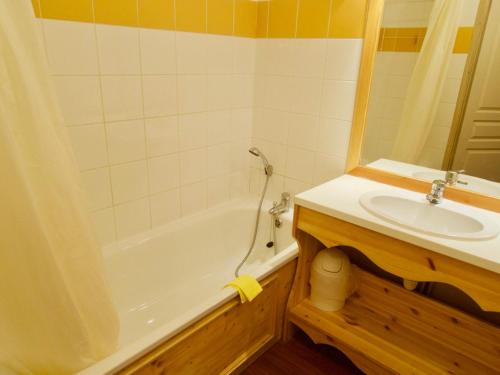 ein Badezimmer mit einer weißen Badewanne und einem Waschbecken in der Unterkunft Appartement Valfréjus, 2 pièces, 6 personnes - FR-1-468-26 in Valfréjus