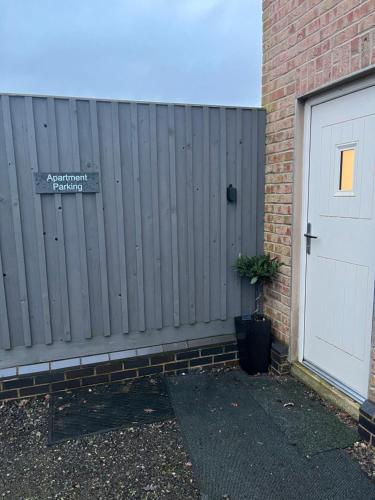 a wooden fence next to a door with a potted plant at The Apartment Cold Comfort Farm in Hinckley