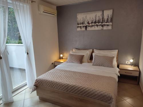 a bedroom with a large bed and a window at Apartments Joško in Makarska