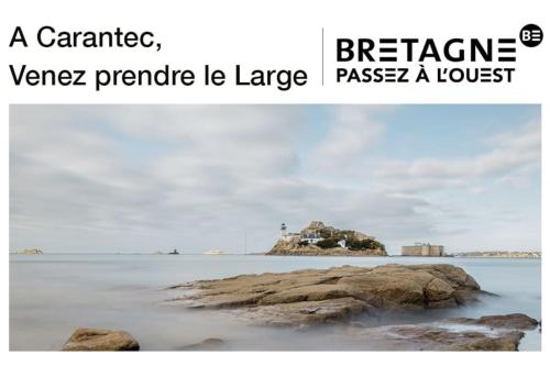 ein Bild eines Strandes mit einem Felsen im Wasser in der Unterkunft Appartement vue sur mer, 100 m de la plage in Carantec