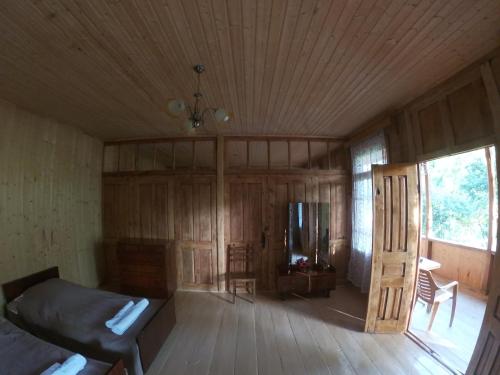 a room with a bed and a wooden floor at Kipiani's guesthouse in Ambrolauri