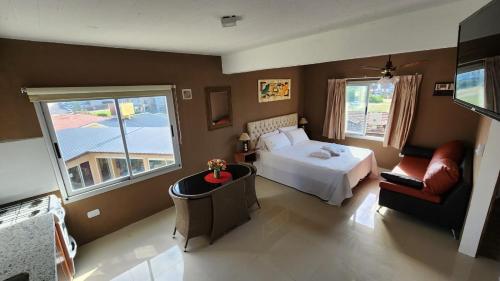 1 dormitorio con cama, sofá y ventana a Departamentos Mirando AL MAR en Villa Gesell