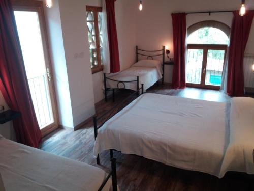 a bedroom with two beds and two windows at B&B Il Pittore in Borgo San Lorenzo