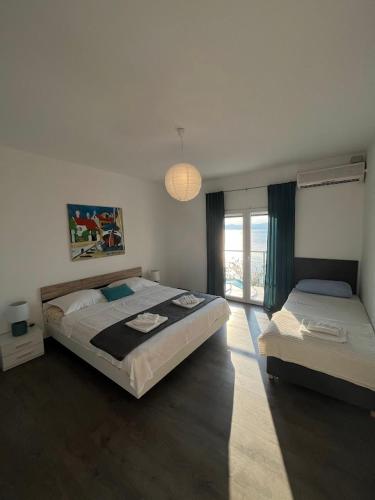 a bedroom with two beds and a window at Blue Art Apartment in Sveti Juraj