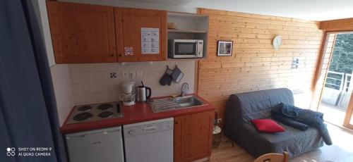 une petite cuisine avec un évier et une cuisinière dans l'établissement STUDIO CHAMROUSSE 1700 pour 4 personnes - Au calme - Avec WIFI, à Chamrousse