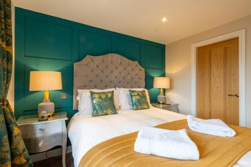 a bedroom with a large bed with a green wall at Holly Lodge Guest House with FREE off site health club in Windermere