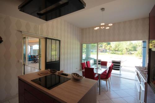 une cuisine avec une table et une salle à manger dans l'établissement Domaine du Haou - Grand gîte au cœur d'un domaine bucolique, à Saint-Laurent-de-Gosse