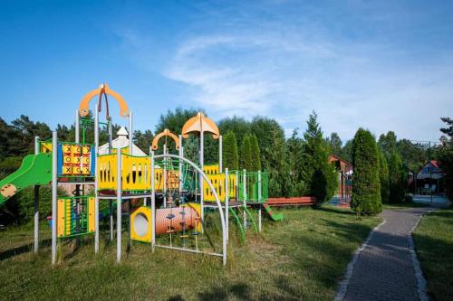 un parque con parque infantil con tobogán en Domki Jagoda, en Dębki