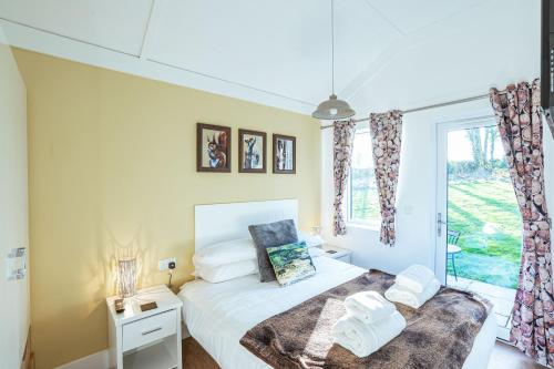 a bedroom with a bed and a window at Squirrel Lodge 41 with Hot Tub in Newton Stewart