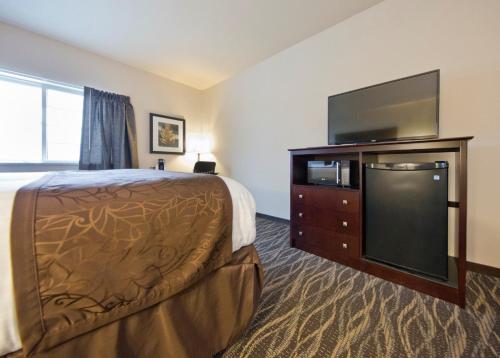 a hotel room with a bed and a flat screen tv at Cobblestone Inn & Suites -Clarinda in Clarinda