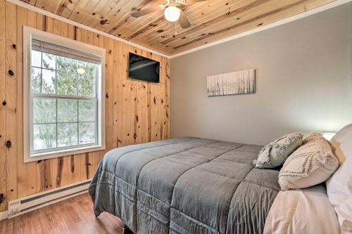 a bedroom with a bed and a window at Cozy Elmira Cabin with Deck, 23 Mi to Slopes! 