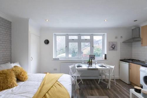1 dormitorio con cama, mesa y cocina en (S3) Studio In South Harrow!, en Harrow on the Hill