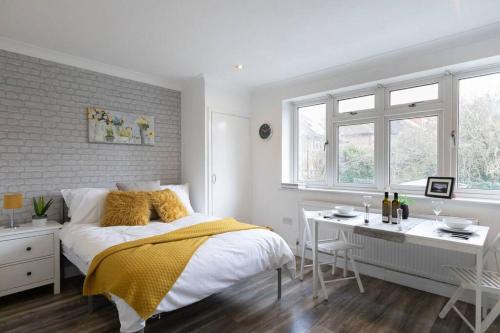 1 dormitorio con 1 cama, escritorio y ventanas en (S3) Studio In South Harrow! en Harrow on the Hill