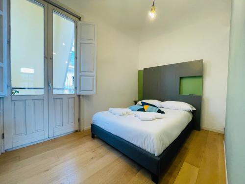 ein Schlafzimmer mit einem Bett und einem großen Fenster in der Unterkunft Dimora del Mercante in Catania