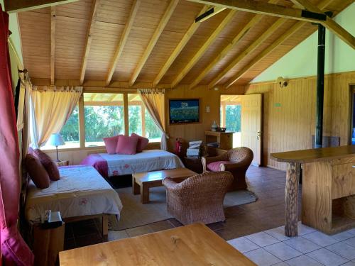 La JuntaにあるLos Coihues Patagonia Lodgeのベッド2台とテーブルが備わる広い客室です。