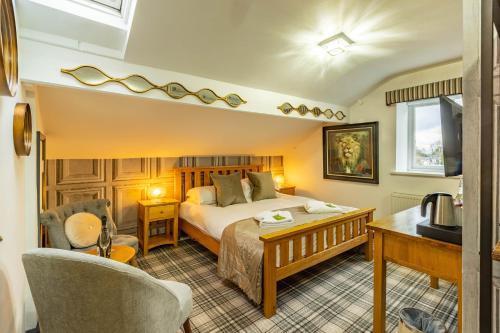 a bedroom with a bed and a desk and a chair at Holly Lodge Guest House with FREE off site health club in Windermere