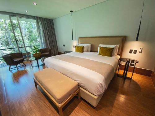 ein Schlafzimmer mit einem großen Bett und einem großen Fenster in der Unterkunft Selvaje Lodge Iguazu in Puerto Iguazú