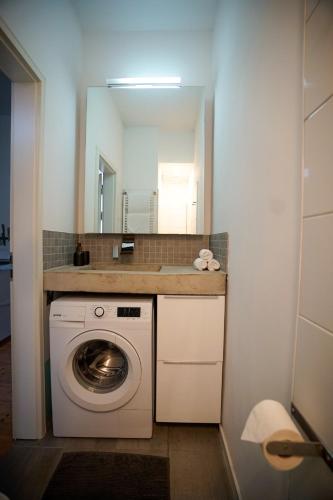 a washing machine in a bathroom with a mirror at pestahome in Hannover