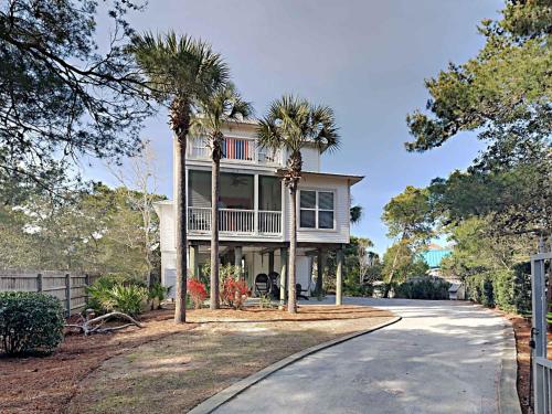 a house with palm trees in front of a driveway at Aloha Sandy Bay in Blue Mountain Beach