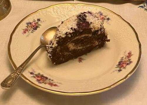 a piece of cake on a plate with a spoon at Pensiunea Deceneu in Slănic
