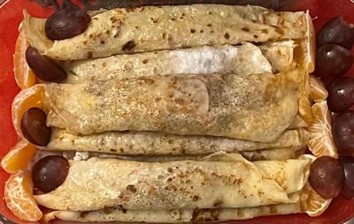 a red plate with five burritos and oranges and olives at Pensiunea Deceneu in Slănic