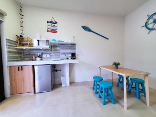 a kitchen with a wooden table and blue stools at SUITES BRISAMAR PLAYA SANTA MARIANITA Manta in Manta