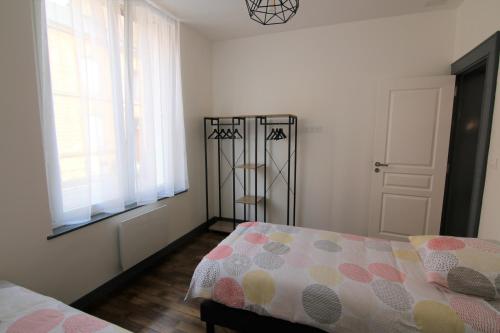 une chambre avec un lit et une fenêtre dans l'établissement Joli appartement avec petit jardin privatif, à Charleville-Mézières