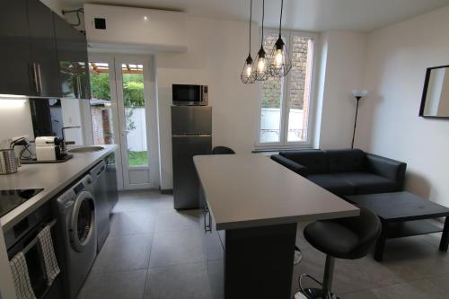 une cuisine et un salon avec une table et des chaises dans l'établissement Joli appartement avec petit jardin privatif, à Charleville-Mézières