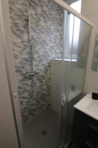 une salle de bain avec une douche avec une porte vitrée dans l'établissement Joli appartement avec petit jardin privatif, à Charleville-Mézières