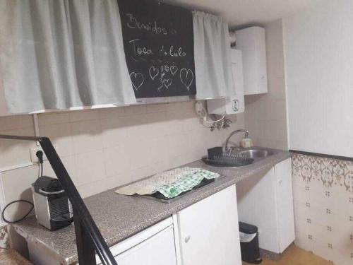 a kitchen with a sink and a chalkboard on the wall at A Toca do Cuco na Vila da Sertã in Sertã
